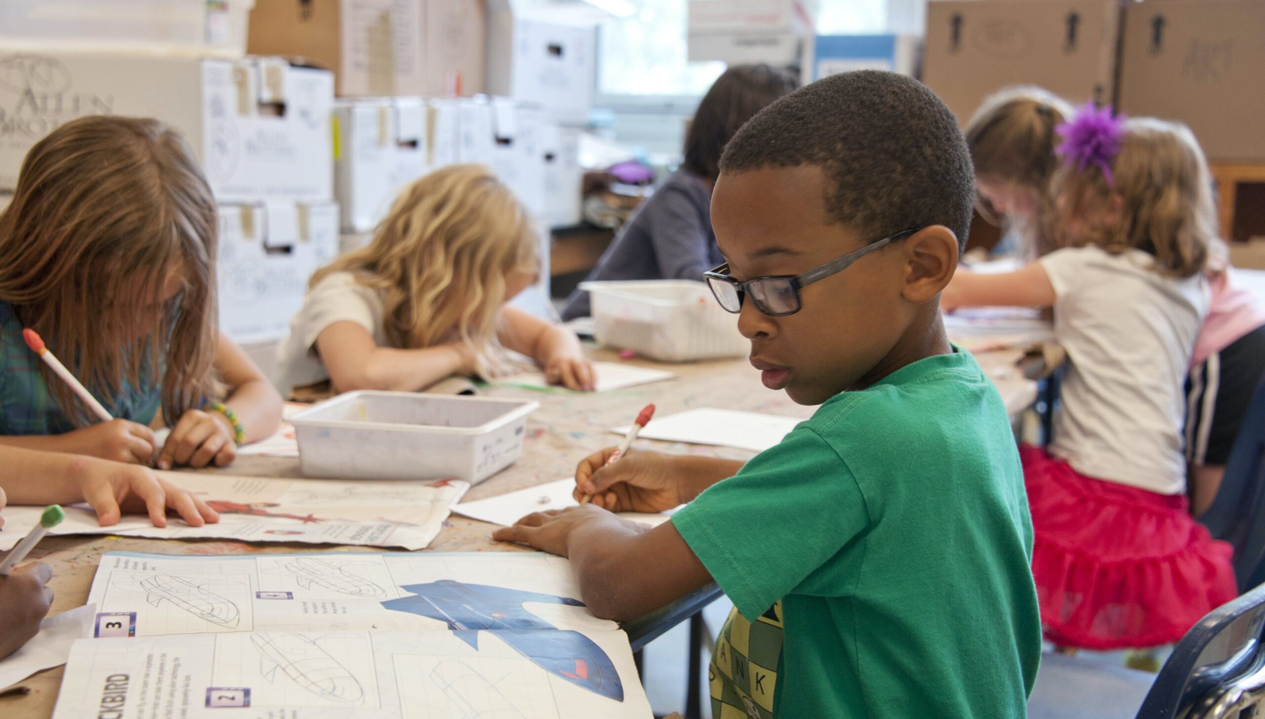 Stock image of children coloring at a table