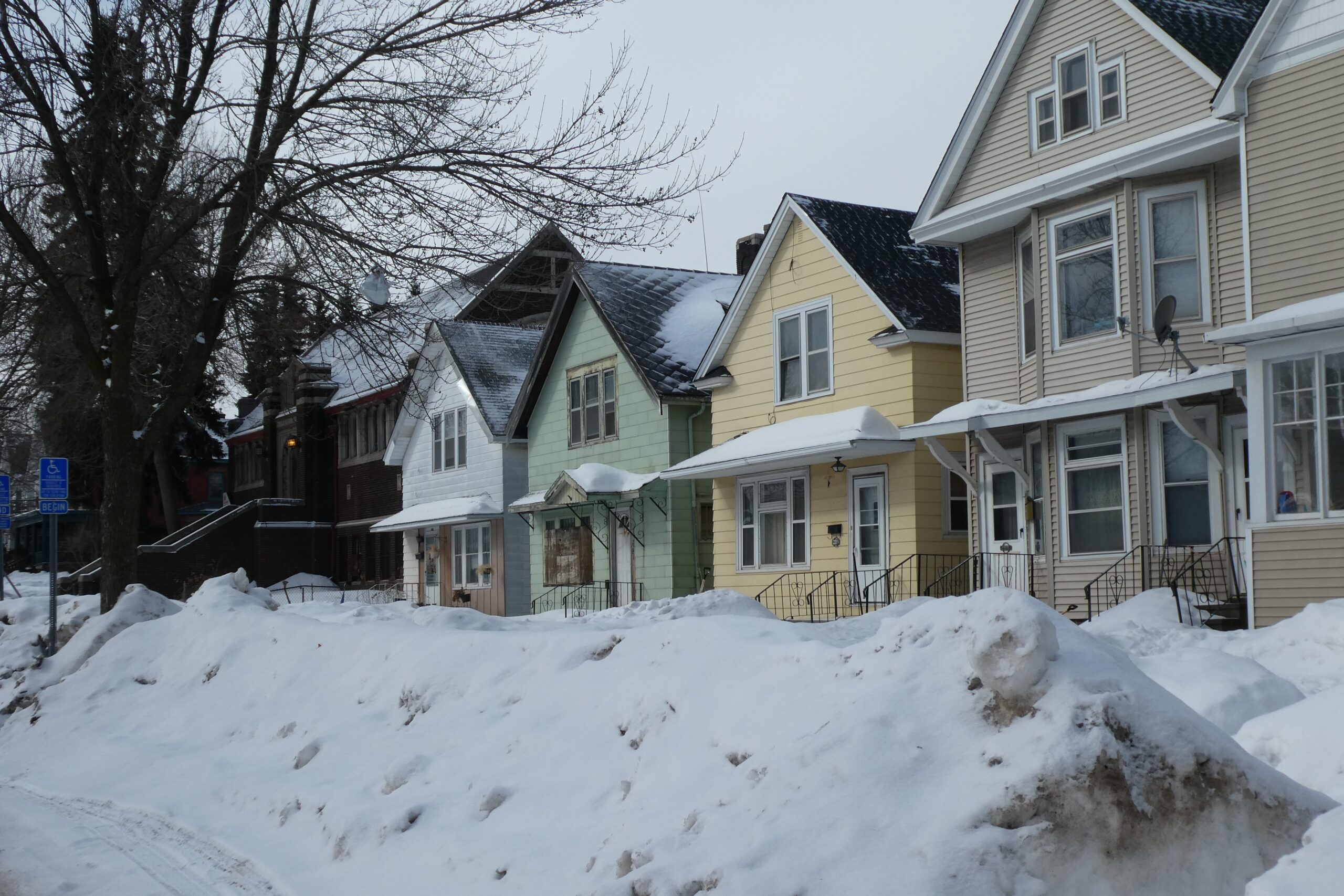 row of homes behind snow bank