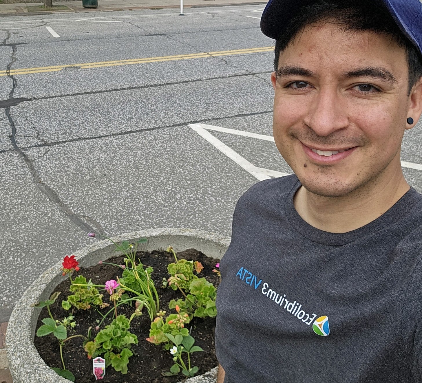 Smiling person poses by planter
